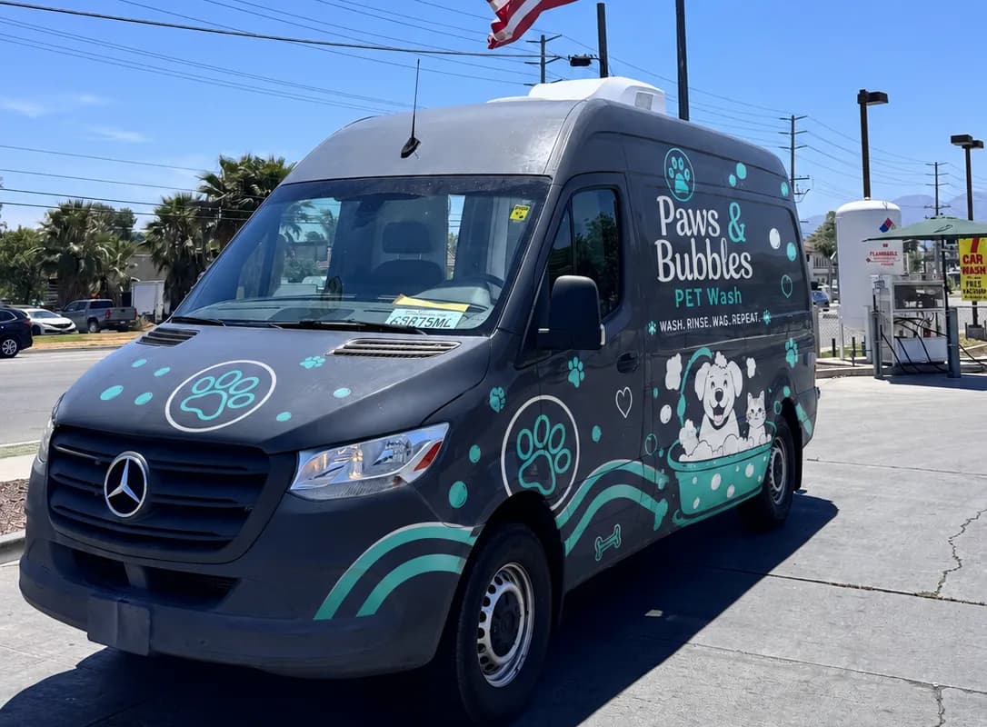The California demo grooming van shown with an example customer brand wrap