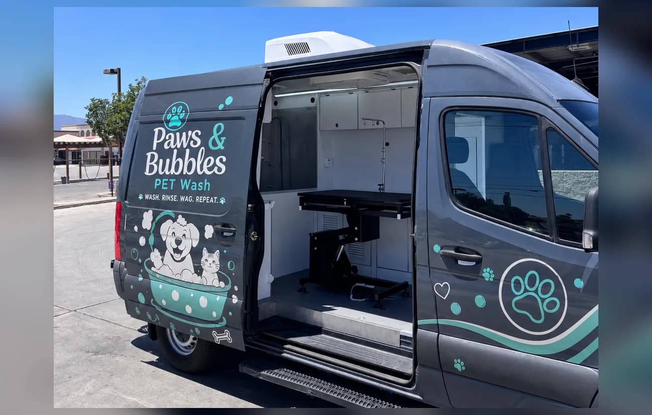Spring Le Tour mobile grooming van finished with an example pet-wash brand wrap, side door open to the salon